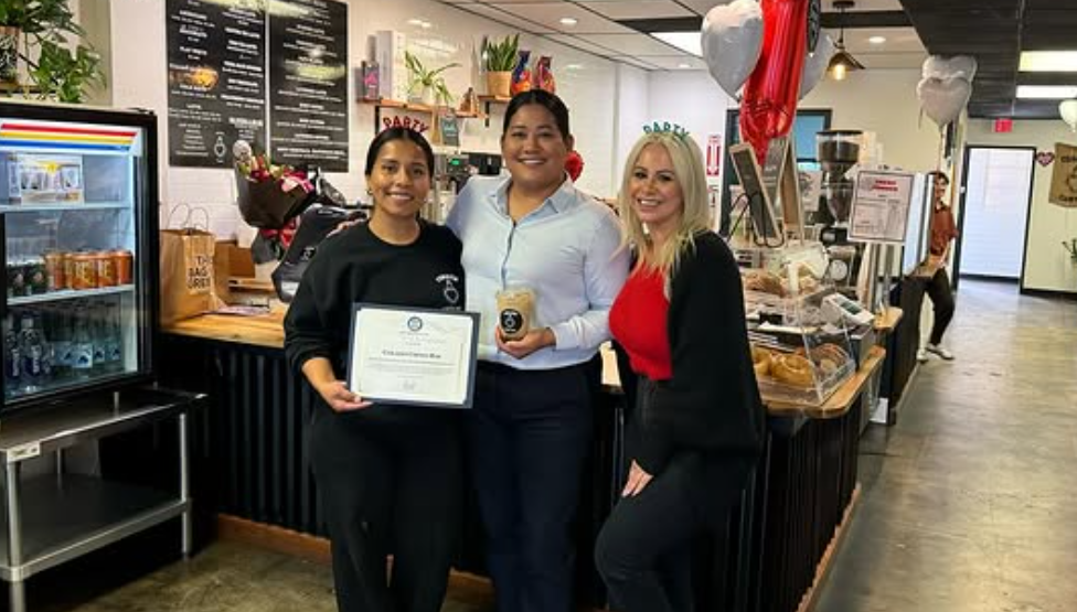 The Corazón team receiving a community recognition certificate at the counter